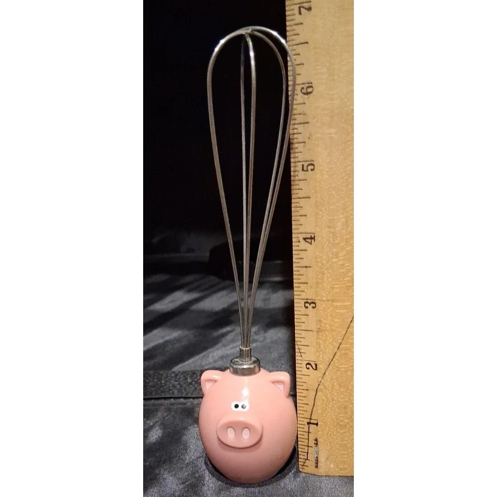 Novelty pig-themed whisk with a pink resin handle. By Jo!e